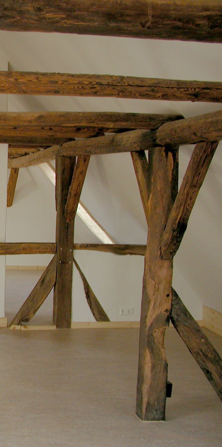 Dachkonstruktion von Innen In einem Dachgeschoss-Raum mit Holzkonstruktion und Lehmputz.