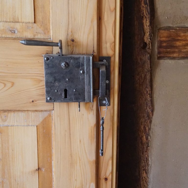 Holztür mit altem Schlossmechanismus Alter, silberner Türschlossmechanismus an einer Holz Tür mit angrenzender Fachwerkwand und Lehmputz.